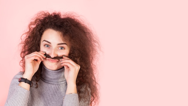 Funny brunette girl portrait on pink background