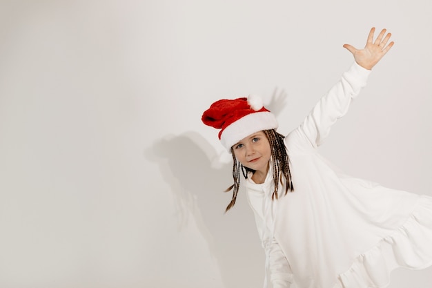 Бесплатное фото Смешная очаровательная девушка в новогодней шапке веселится настроение рождество