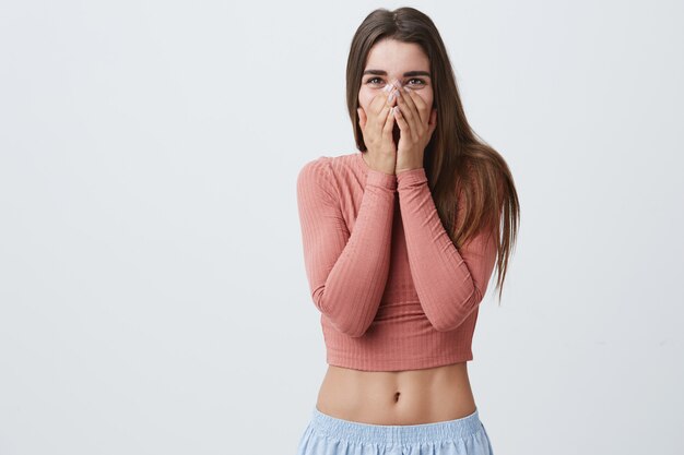 Funny cheerful good-looking brunette caucasian student girl with long hair in fashionable clothes clothing mouth with hands in excitement, when boyfriend offered to engaged