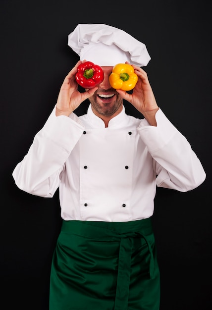 Foto gratuita cuoco unico divertente che copre i suoi occhi di paprika