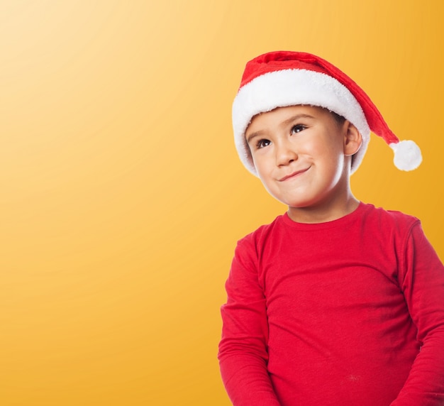 Забавный ребенок носить шляпу Санта с оранжевом фоне