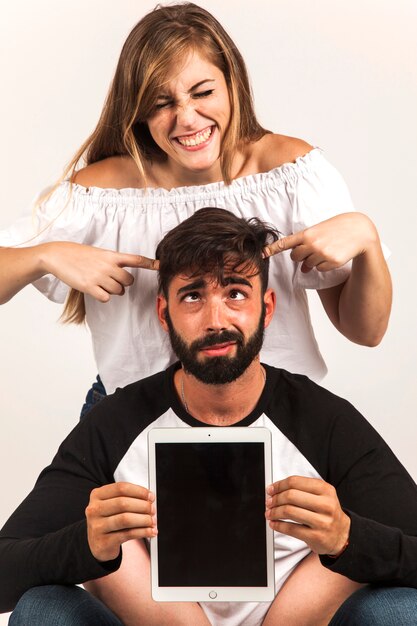 Funny couple showing tablet