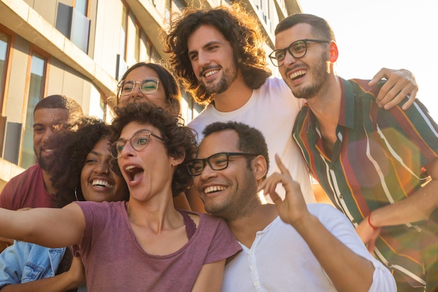 Funny curly haired woman in glasses taking selfie