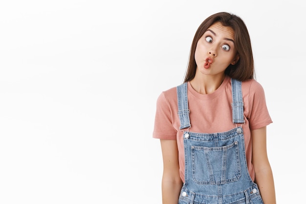 Free photo funny and cute silly woman making crazy weird faces grimacing folding lips like fish and squinting shifting eyes standing white background having fun like playing charades during thanksgiving