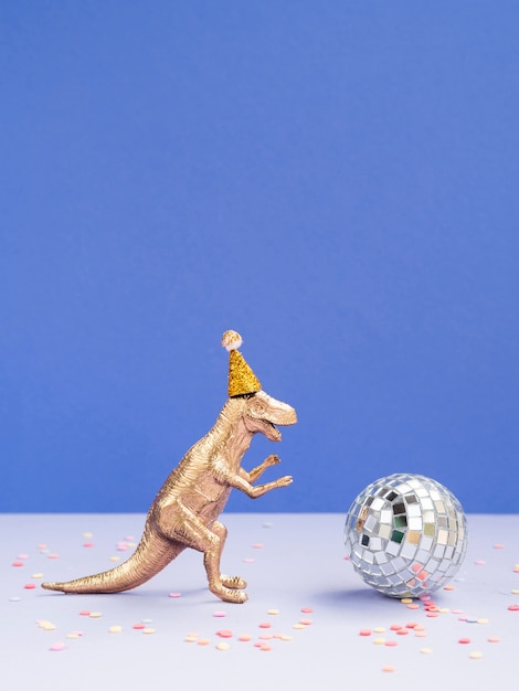 Funny dinosaur with birthday hat and disco globe