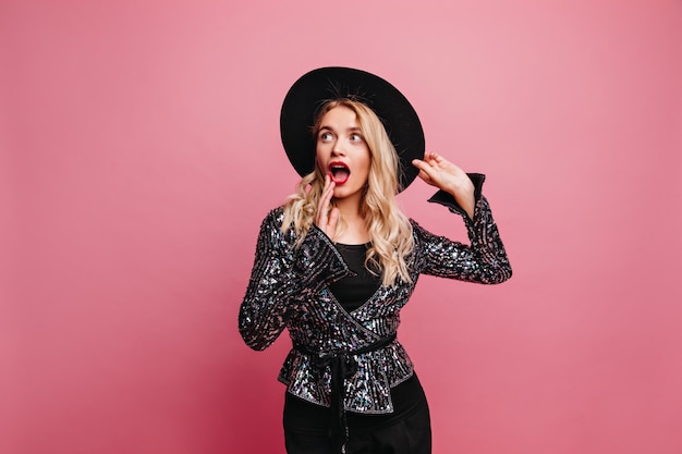 Funny emotional woman posing in hat. Indoor portrait of refined lady looking away.