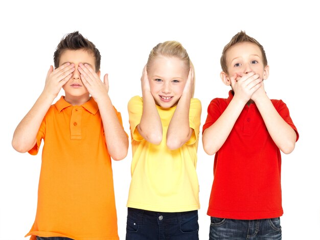 Funny faces of happy children doing "See Nothing, Hear Nothing, Say Nothing..." isolated on white background
