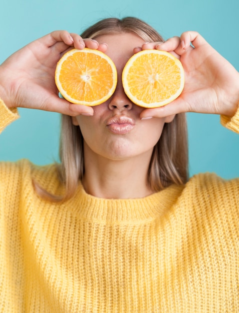 Funny female holding oranges