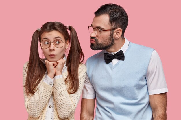무료 사진 두 개의 조랑말 꼬리를 가진 재미있는 여성 괴짜, 큰 안경을 쓰고 남자 친구의 키스를 받으러 가고 첫 데이트가 있습니다.