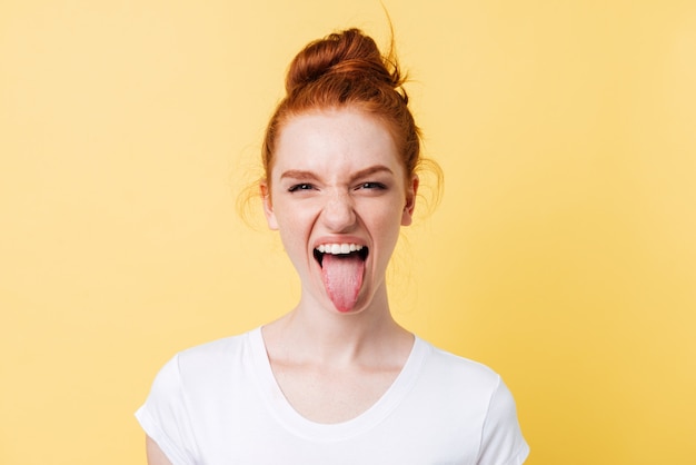 Funny ginger woman showing tongue and looking