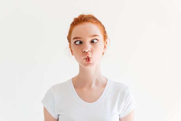 Funny ginger woman in t-shirt showing grimace