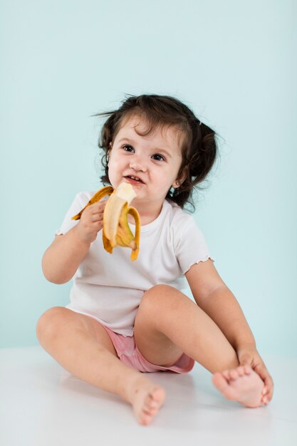 Смешная девчонка ест банан