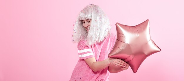 Funny Girl with silver hair gives a smile and emotion on pink background.