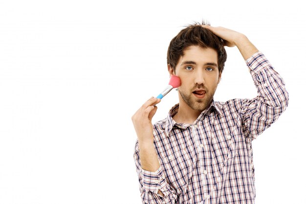 Funny guy mocking girlfriend with makeup brush