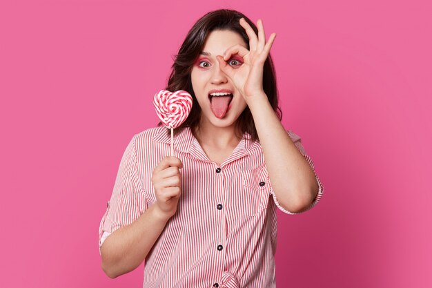 Funny happy young woman makes okay gesture