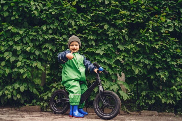 Free photo funny kid in rain boots playing in a rain park