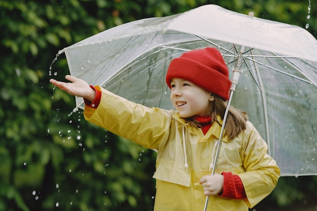 Веселые дети в дождевых сапогах играют у лужи