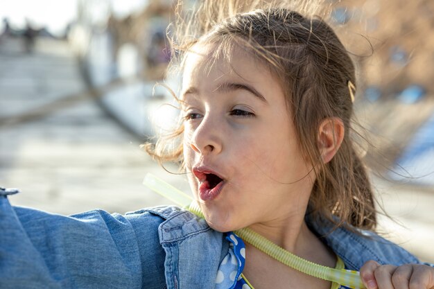 A funny little girl saw something interesting in the distance and points there.