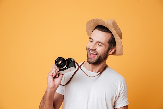 Uomo divertente che esamina retro macchina fotografica antiquata