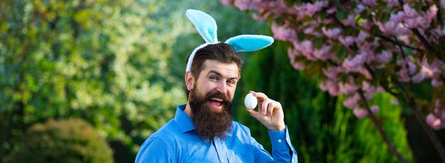 Funny man in rabbit costume with easter eggs banner