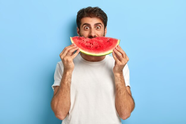 Funny man on a summer day holding a slice of watermelon