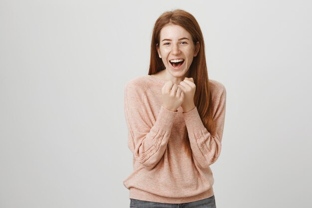 Funny playful redhead girl holding fists for fighting