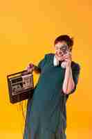 Free photo funny senior woman holding a cassette player