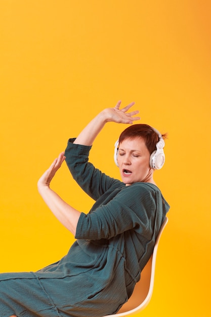 Funny senior woman listening music