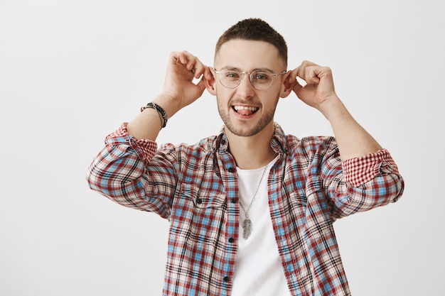 Funny and silly young guy with glasses posing