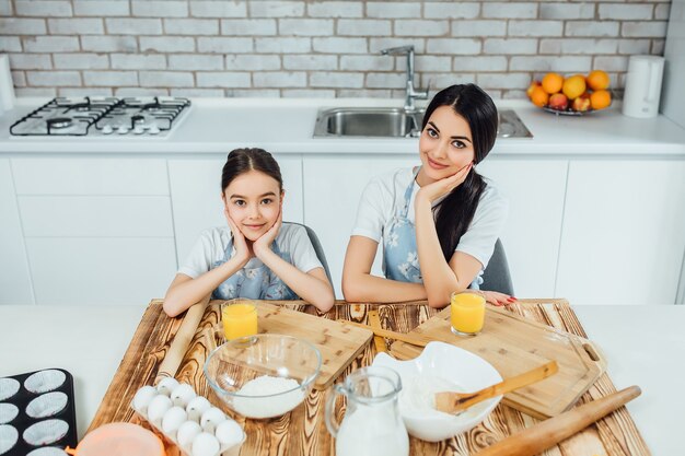 Веселые сестрички готовят тесто, печь печенье на кухне