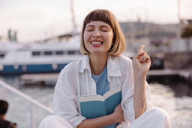 Funny smiling woman sitting with fingers crossed