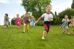 Foto gratuita inizio divertente. concetto di moda per bambini. il gruppo di ragazzi e ragazze adolescenti che corrono al parco.