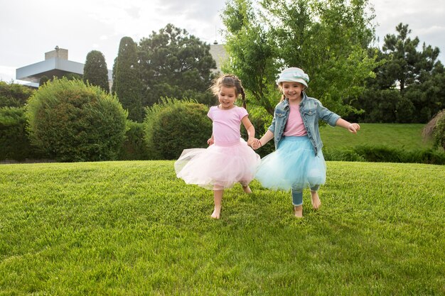 Funny starts. Kids fashion concept. group of teen girls running at park. Children colorful clothes, lifestyle, trendy colors concepts.