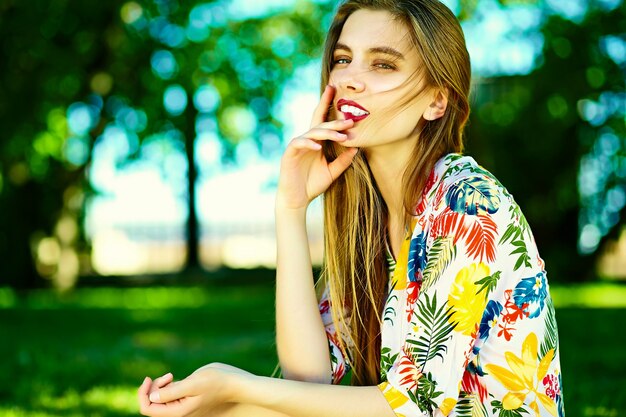 夏の明るい流行に敏感な布ドレスで面白いスタイリッシュなセクシーな笑顔の美しい若い女性モデル
