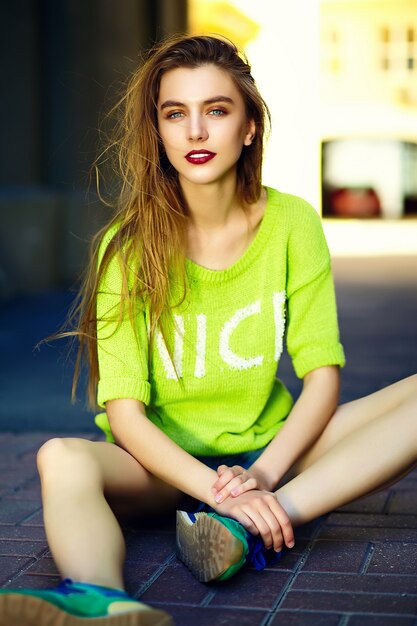 Funny  stylish sexy smiling beautiful young woman model in summer bright yellow   hipster cloth sitting in the street