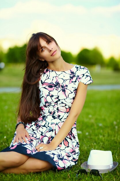 Funny stylish smiling beautiful young woman model in summer bright cloth dress in hat in the park