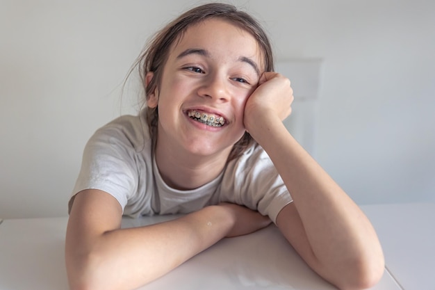 Free photo a funny teenage girl looks at the camera and demonstrates braces on her teeth