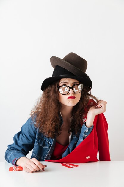 Funny thoughtful shopaholic woman wearing sale signs