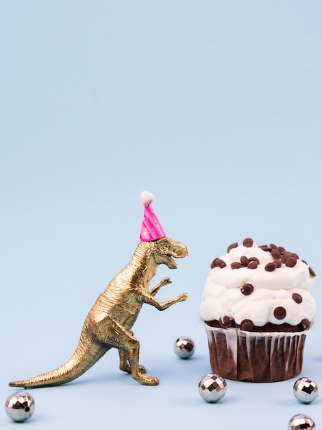 Foto gratuita divertente giocattolo t-rex con cappello compleanno