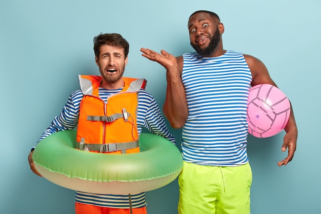 Funny unaware friends posing with beach items