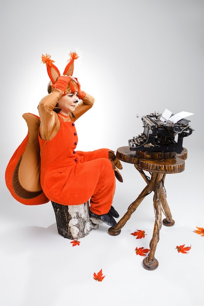 Funny woman dressed as a squirrel, typing with old typewriter