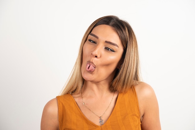 Funny woman showing a tongue on white background.