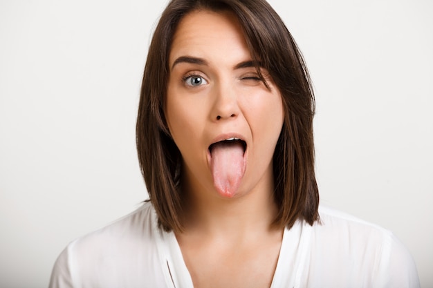 Free photo funny woman wink and show tongue