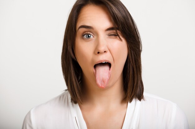 Funny woman wink and show tongue