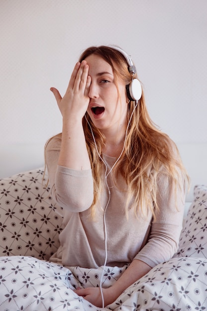 Foto gratuita donna divertente con le cuffie che coprono gli occhi