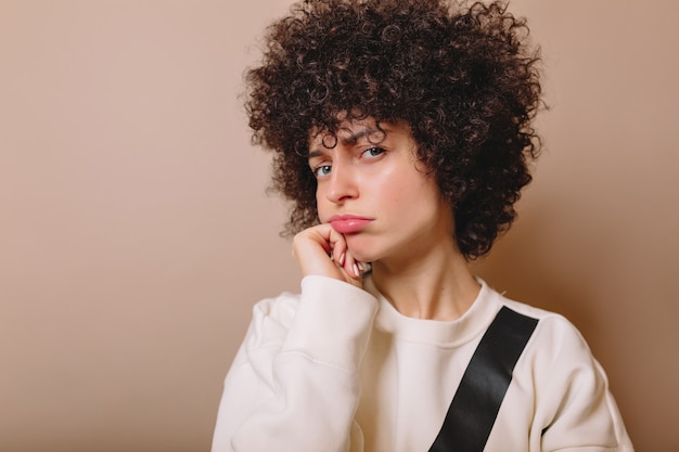 Foto gratuita la donna divertente con le labbra gonfie scherzosamente pone sul beige