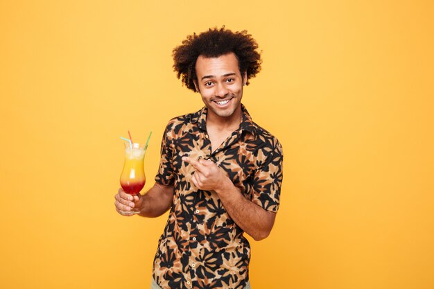 Funny young african man drinking cocktail.