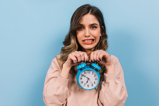 Foto gratuita giovane signora divertente che posa con il grande orologio