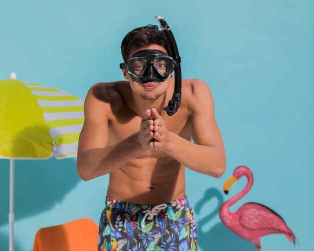 Funny young man in diving mask in studio