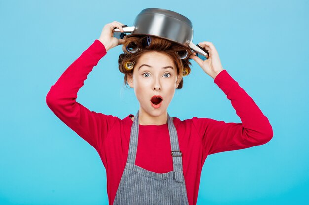 Funny young woman poses with soucepan on head